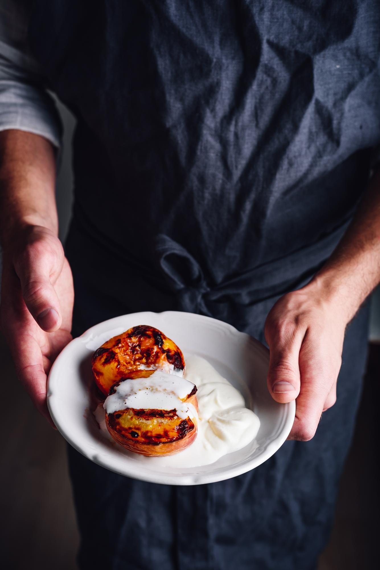 Chef arranging plated dish in rustic studio